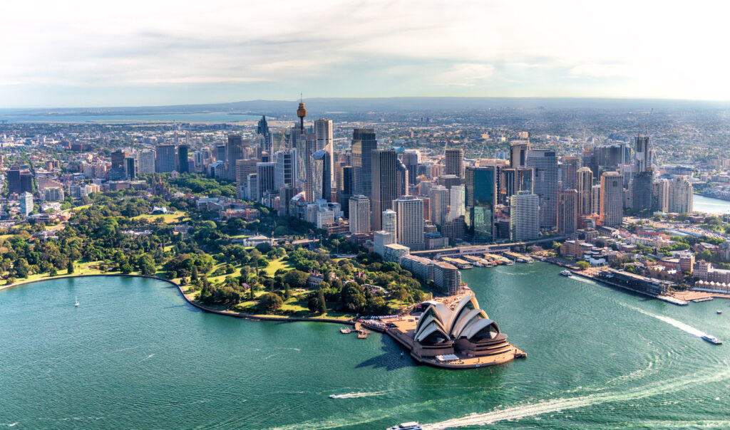 Aerial view of Sydney's skyline featuring the iconic Sydney Opera House and lush green parks, illustrating the vibrant urban landscape relevant to mortgage options and financial services in Sydney.