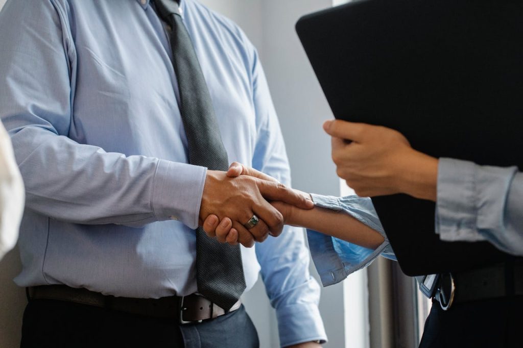 Business professionals shaking hands, symbolising successful negotiation and partnership in finance and mortgage solutions.