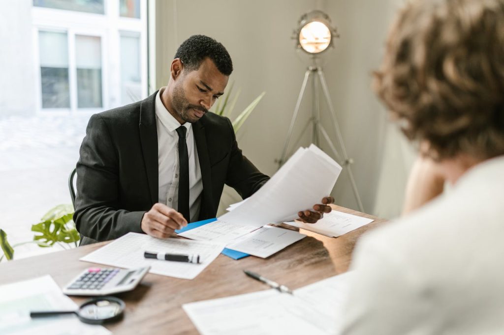 Professional mortgage broker discussing paperwork with a client in a modern office setting, highlighting financial consultation and loan options in Sydney.