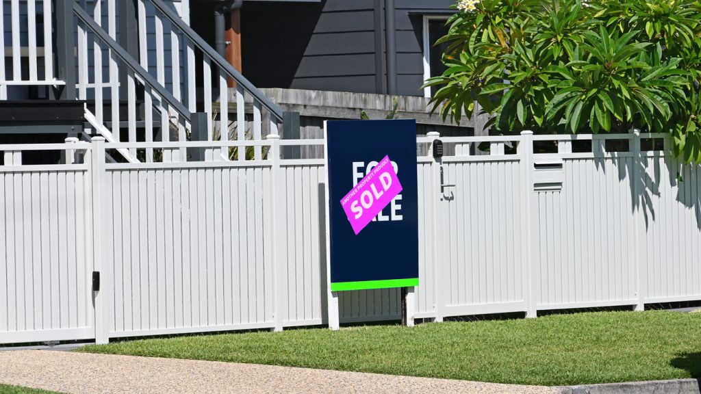 Sold sign in front of a house, indicating successful real estate transaction, relevant to mortgage refinancing and financing options.