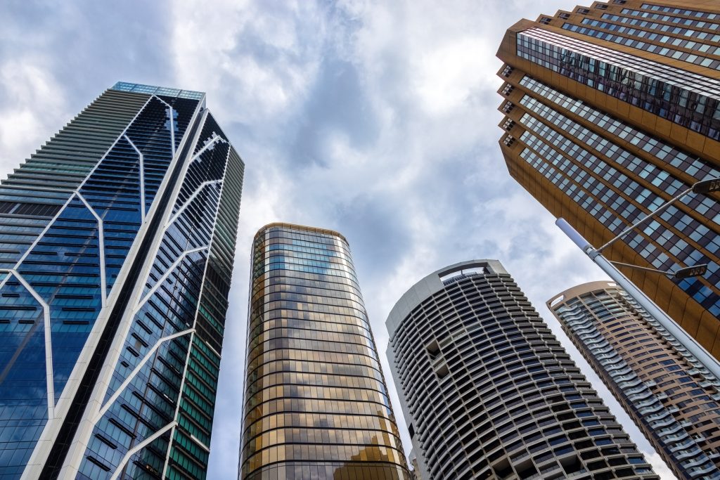 Modern commercial skyscrapers against a cloudy sky, reflecting the themes of business financing and property investment in urban settings.