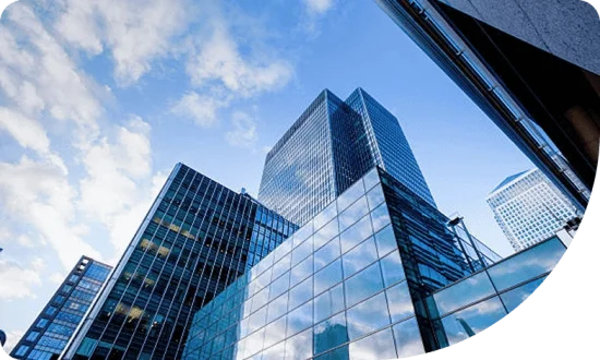 Modern commercial buildings with reflective glass facades against a blue sky, symbolizing business growth and investment opportunities.