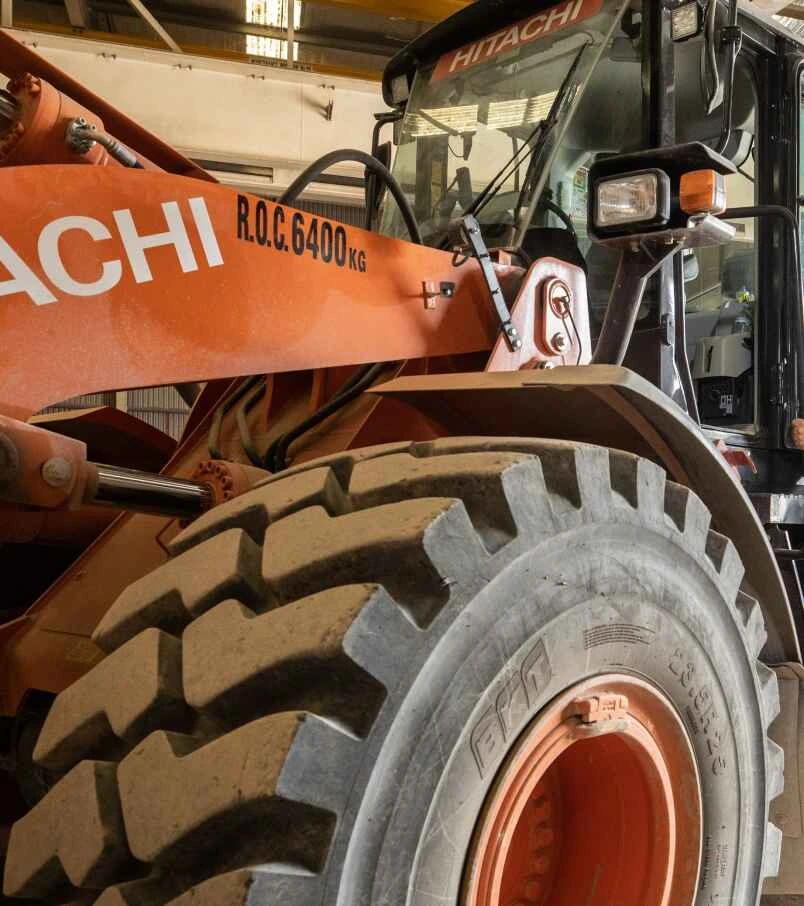 Hitachi construction equipment with a large tire, showcasing asset financing options for businesses needing essential machinery.