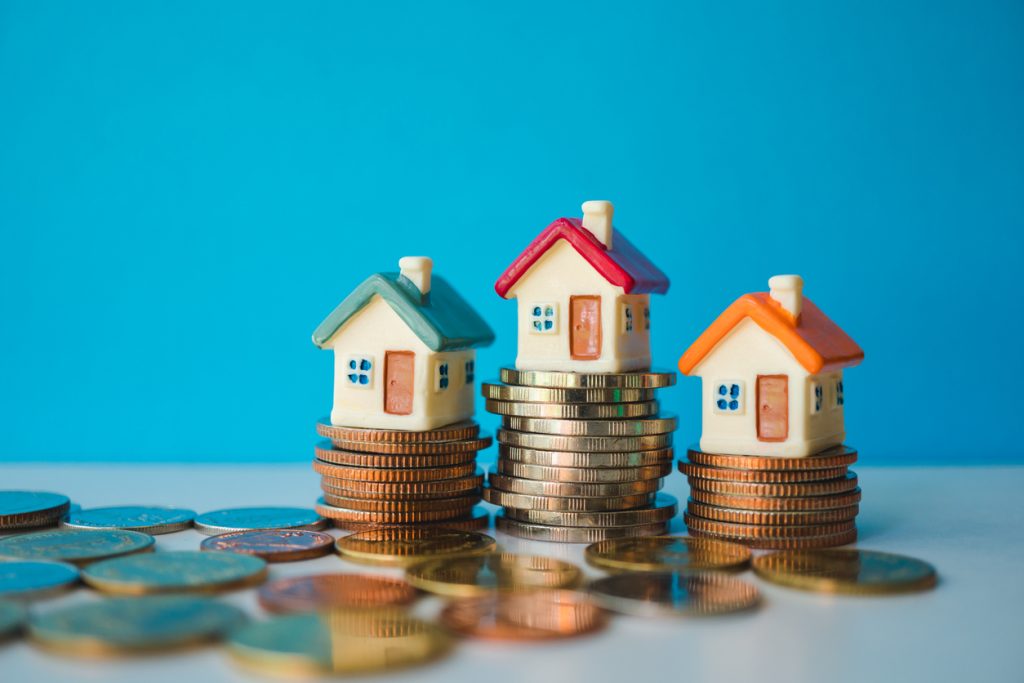 Model houses on stacks of coins representing home loan financing and refinancing options in Australia.