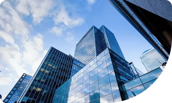 Modern commercial buildings with reflective glass facades against a blue sky, symbolizing Trelos Finance's commercial loan services for business expansion.
