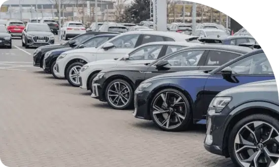 Row of various modern vehicles in a dealership parking lot, showcasing options for car loans and vehicle finance solutions.