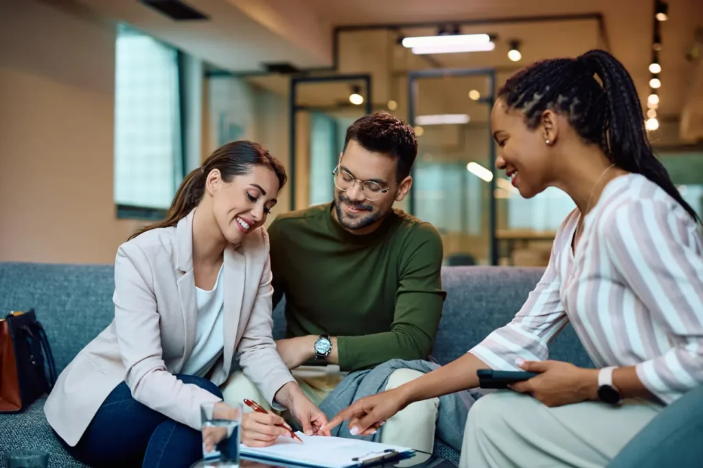 Couple consulting with mortgage broker in modern office setting, discussing home loan options and financial advice.